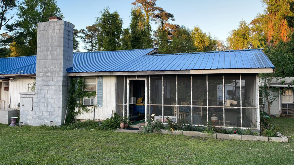 An image of a house with a blue metal roof